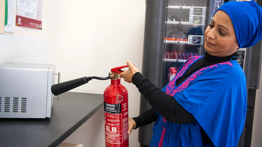 Fire marshal using a fire extinguisher on a fire