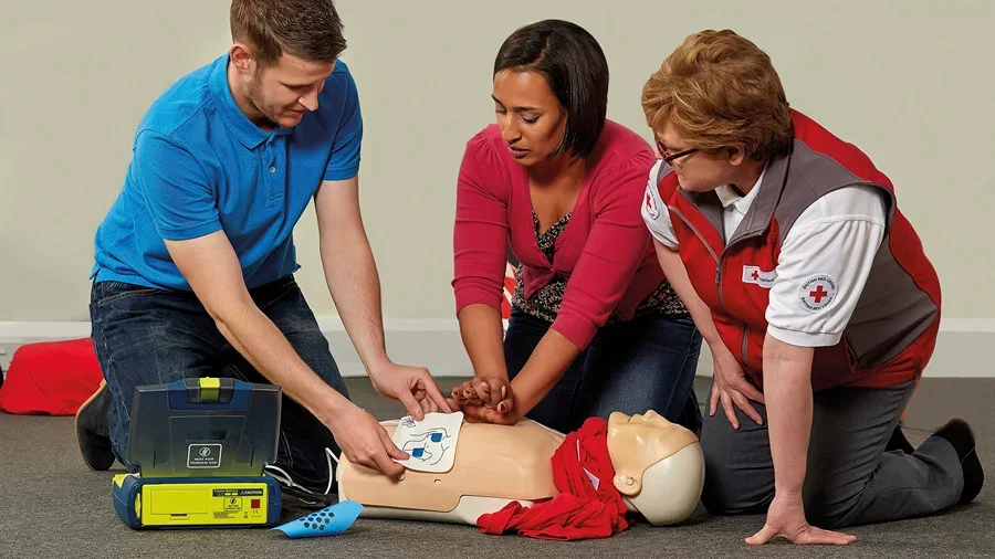 First aider learning how to use aed pads on a course