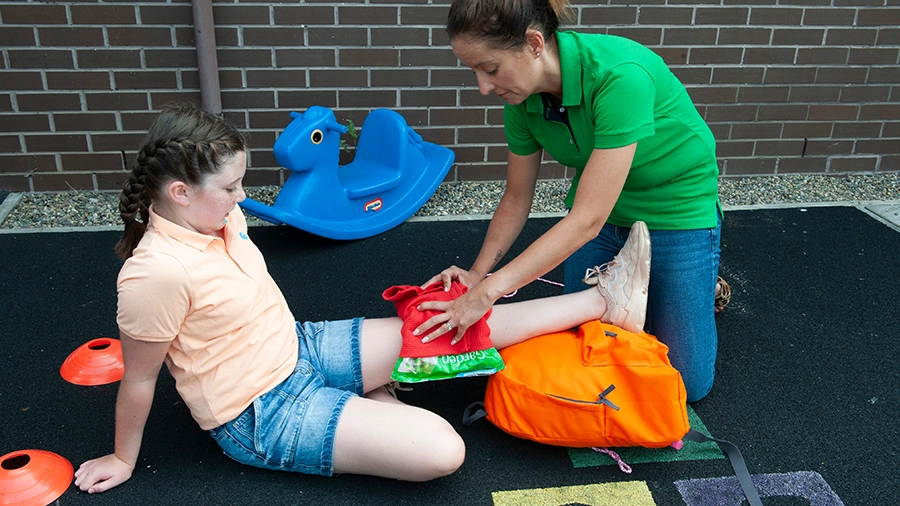 Injured child receiving first aid from a paediatric first aider